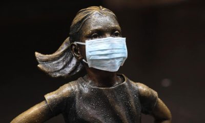 Photo of the "Fearless Girl" with a mask