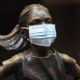 Photo of the "Fearless Girl" with a mask