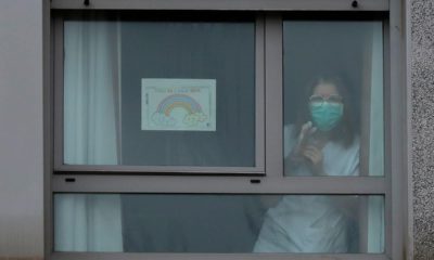 Photo of a nurse looking out the window of a nursing home