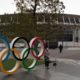 Photo of a woman posing by the Olympics rings in Tokyo