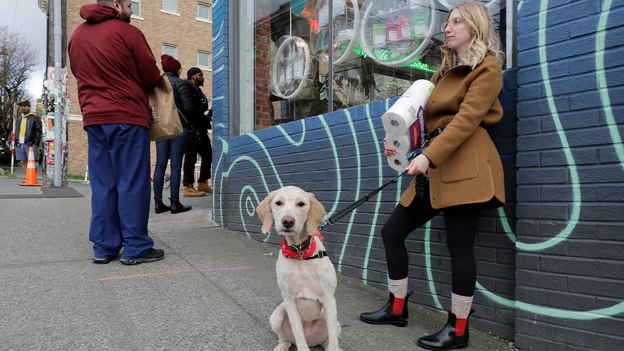 Photo of a woman and her dog waiting in line in Seattle