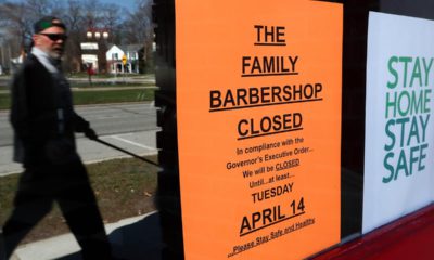 Photo of a man walking by a closed sign
