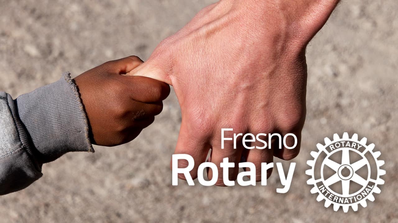 Composite of a man grabbing a child's hand with the Fresno Rotary logo po