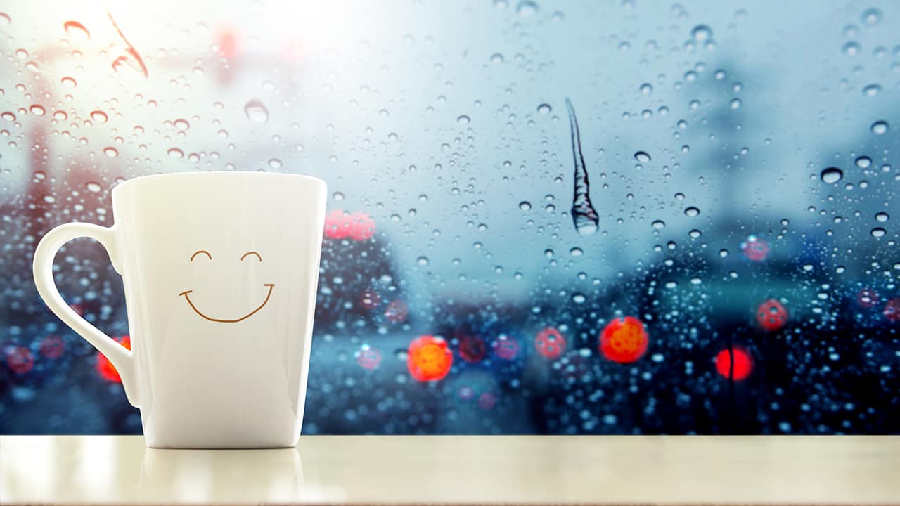 Photo of a happy face mug with rain droplets in the background
