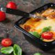 Photo of baked lasagna in a to-go container