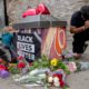 Photo of people around a makeshift memorial