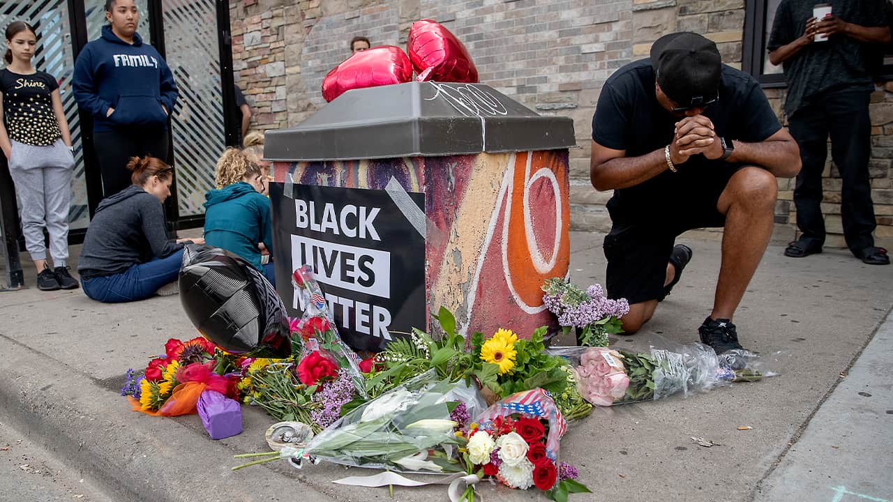 Photo of people around a makeshift memorial