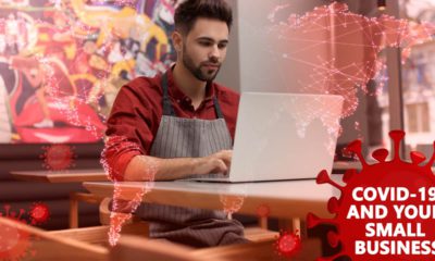 Composite image of a small businessman at laptop and COVID-19 symbols