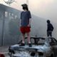Photo of a man standing on a burnt car