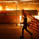 Photo of a protester carrying a flag upside down