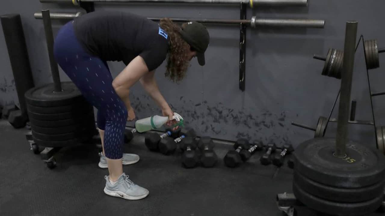 Photo of a woman cleaning weights