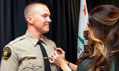 Photo of Deputy Nicholas Dreyfus receiving his badge from his wife
