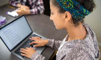 Photo of a female high school student using her laptop to access an online school