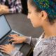 Photo of a female high school student using her laptop to access an online school
