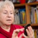 Image of a woman dialing a smartphone in a room filled with books