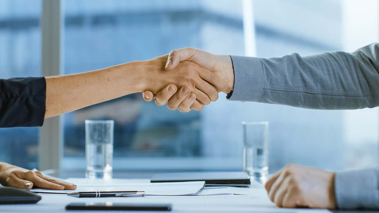 Image of a man and woman shaking hands symbolizing a business merger