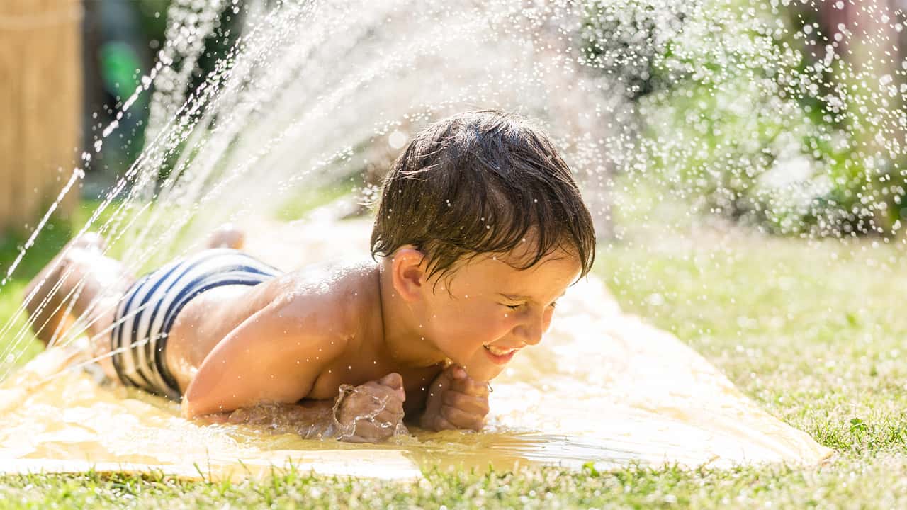 Photo of a child cooling off with a sprinkler